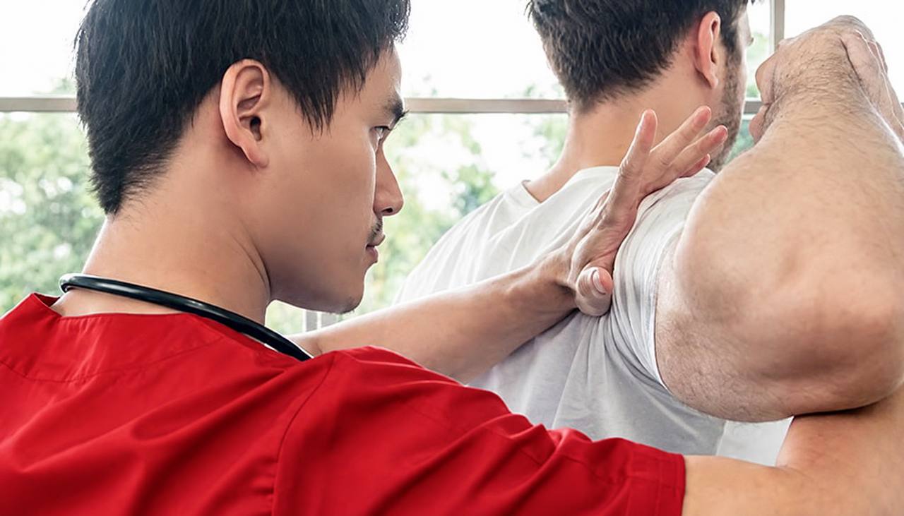 Sakit Bahu Akibat Dislocate: Apa Yang Fisioterapi Boleh Bantu? 3 Fisioterapis menjalankan rawatan manual pada bahu pesakit dalam sesi rehabilitasi